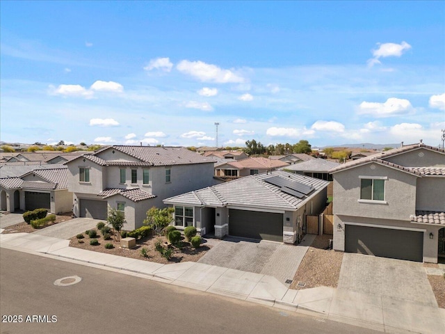 view of front of house with a tiled roof, driveway, a residential view, and stucco siding