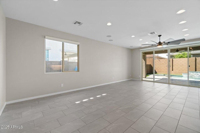 empty room with plenty of natural light, a ceiling fan, and visible vents