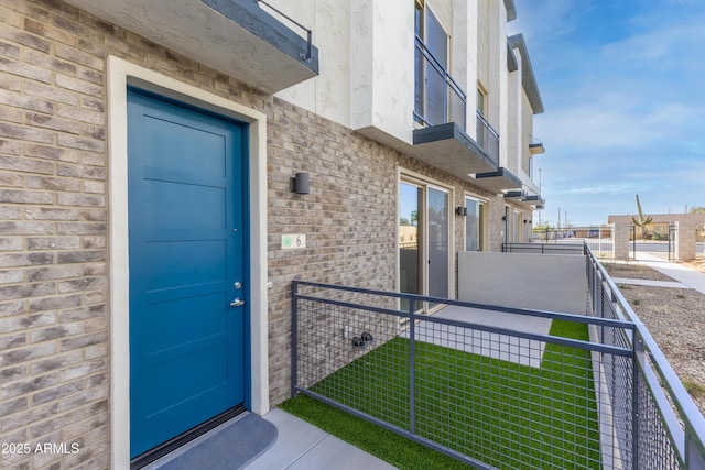 651 N Ironwood Rd Unit 9-12, Apache Junction, AZ 85119 - property entrance with a balcony, brick siding, a yard, and stucco siding