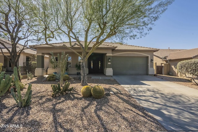 view of front of home with a tile roof, concrete driveway, a garage, and stucco siding