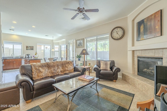 living room with light tile patterned floors, visible vents, recessed lighting, and a tiled fireplace