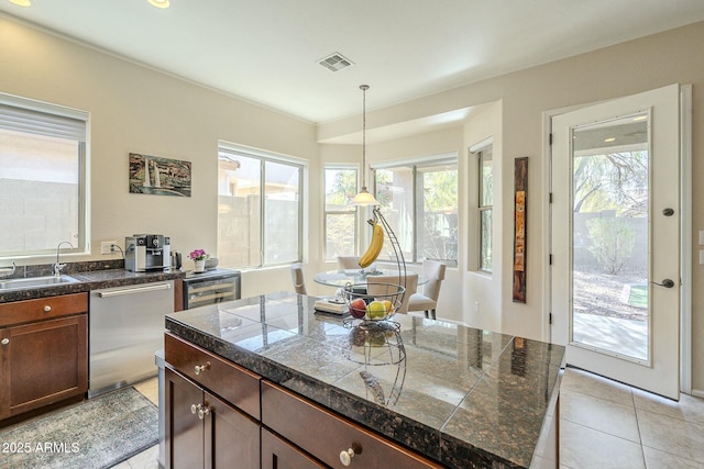 kitchen featuring beverage cooler, light tile patterned flooring, a sink, tile counters, and stainless steel dishwasher