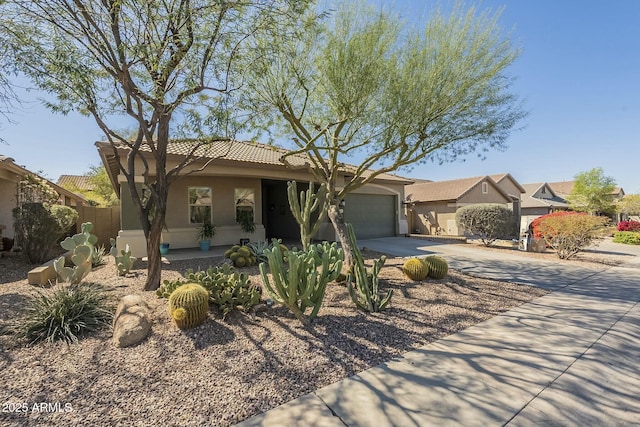 view of front of house featuring stucco siding, an attached garage, driveway, and a tile roof