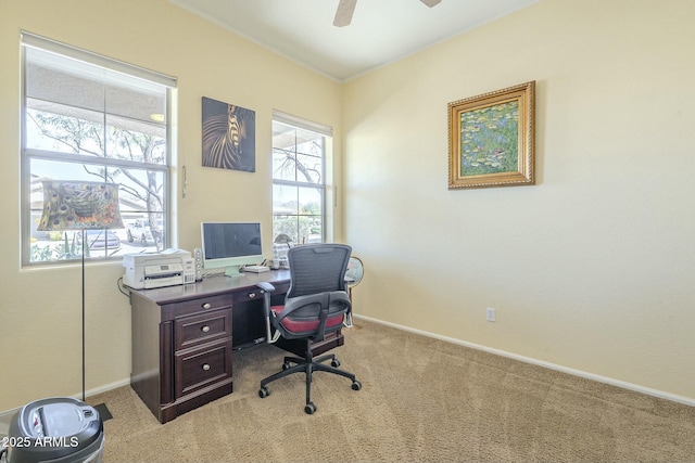 carpeted home office featuring baseboards, plenty of natural light, and ceiling fan