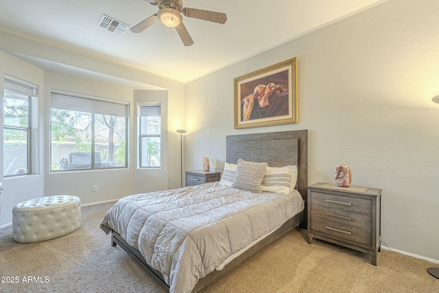 bedroom featuring visible vents, baseboards, light colored carpet, and a ceiling fan