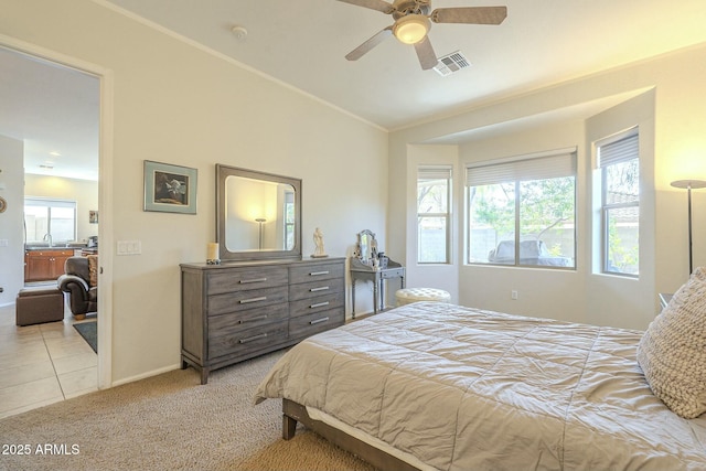 carpeted bedroom with lofted ceiling, multiple windows, visible vents, and a sink