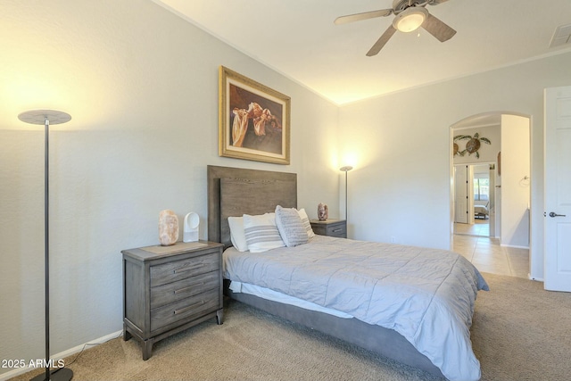 carpeted bedroom with arched walkways, visible vents, ceiling fan, and baseboards