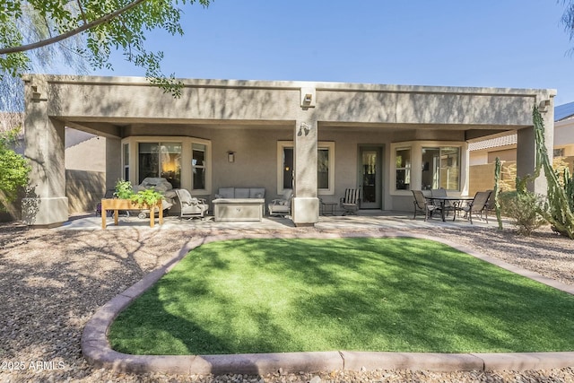 back of house featuring a patio area, stucco siding, and a yard