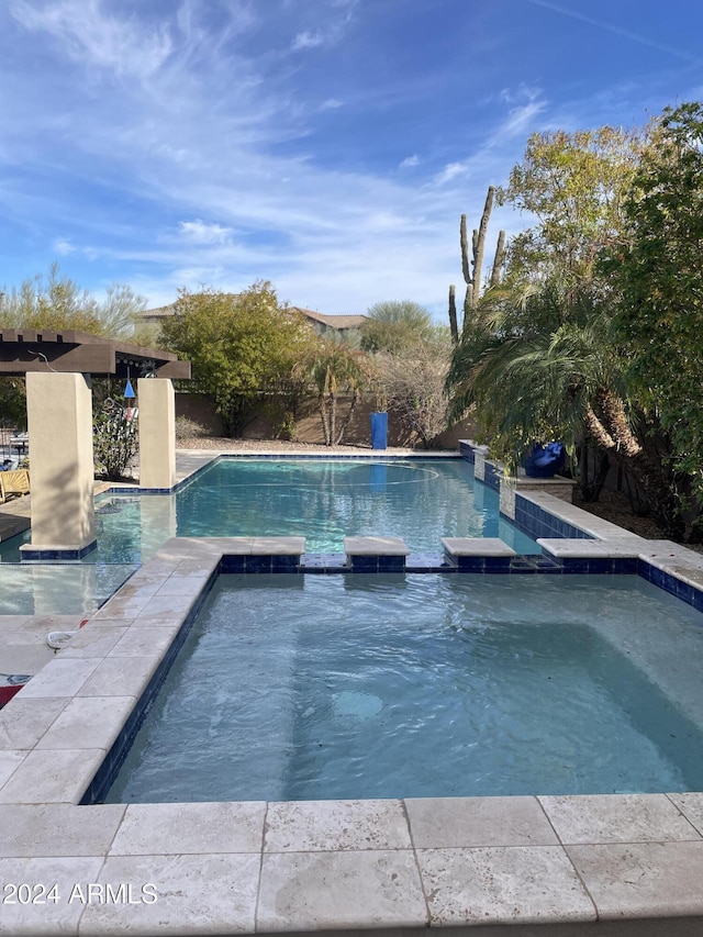 view of swimming pool featuring an in ground hot tub