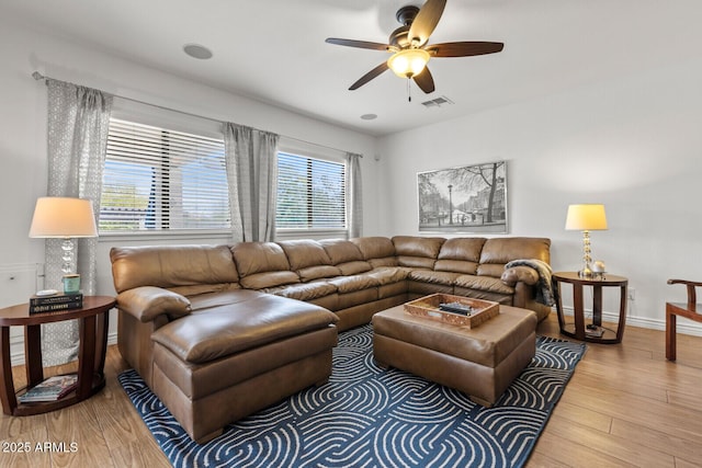 living room featuring ceiling fan, wood-type flooring, and plenty of natural light