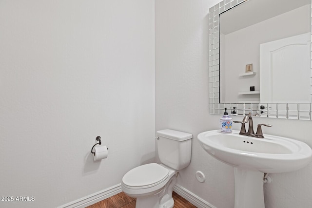 bathroom with toilet, wood-type flooring, and sink