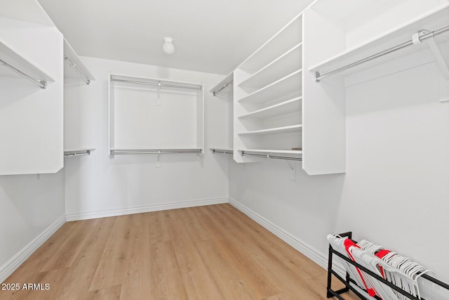 walk in closet with light hardwood / wood-style floors