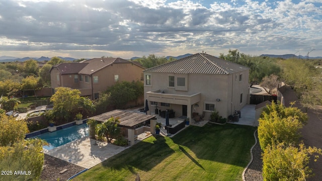 rear view of property with a lawn and a patio