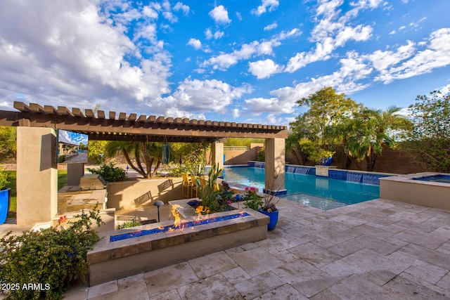 view of pool with a patio area, a jacuzzi, an outdoor kitchen, and pool water feature