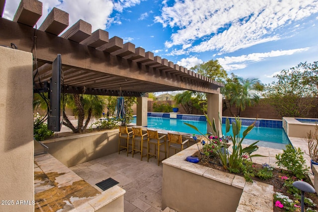 view of pool featuring a pergola, pool water feature, a patio area, and an outdoor bar