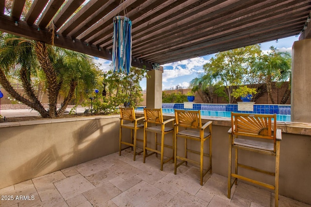 view of patio featuring a pergola and exterior bar