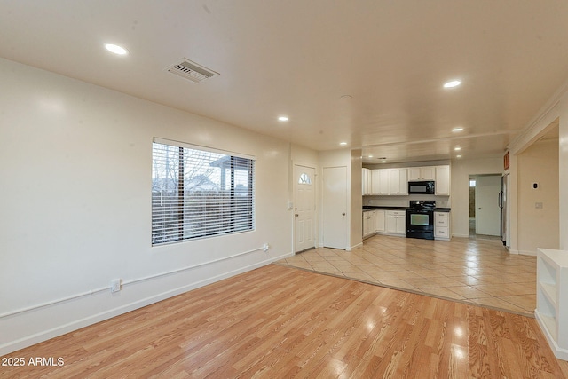 unfurnished living room featuring light wood-style floors, recessed lighting, visible vents, and baseboards