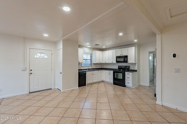 kitchen with dark countertops, white cabinetry, black appliances, and light tile patterned floors