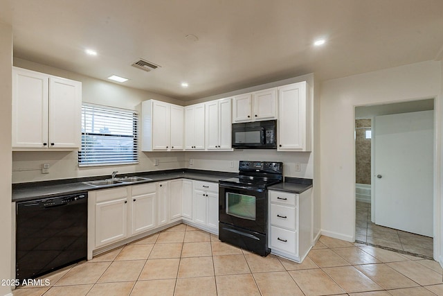 kitchen featuring dark countertops, visible vents, light tile patterned flooring, a sink, and black appliances