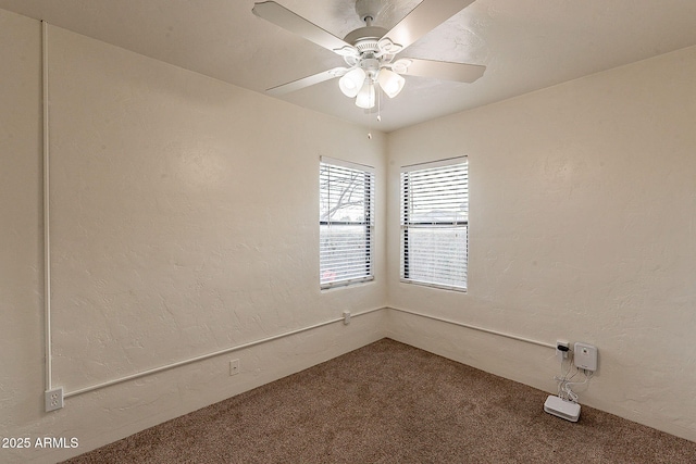 carpeted spare room with a textured wall and ceiling fan