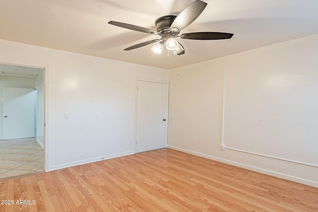 empty room with light wood-type flooring, baseboards, and a ceiling fan