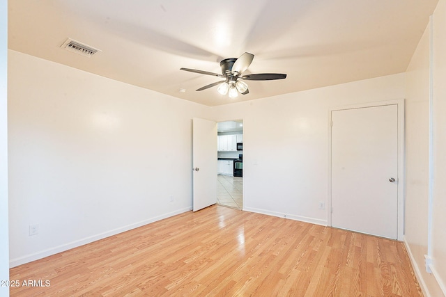 unfurnished bedroom featuring light wood-style flooring, visible vents, ceiling fan, and baseboards