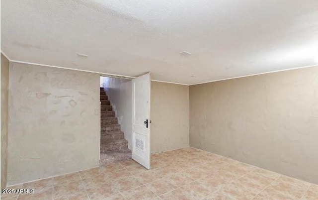 empty room with stairway and a textured ceiling