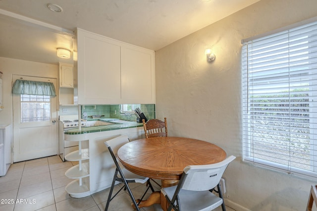 dining room featuring a textured wall and light tile patterned floors