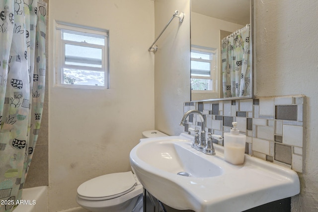 full bath featuring toilet and decorative backsplash