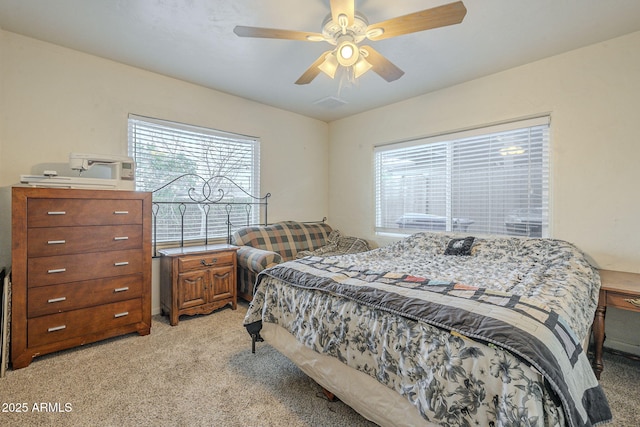 bedroom featuring light carpet and a ceiling fan