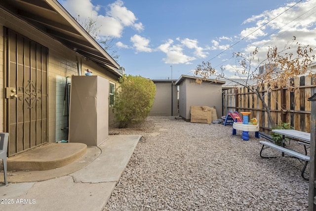 view of yard featuring a shed, an outdoor structure, and fence