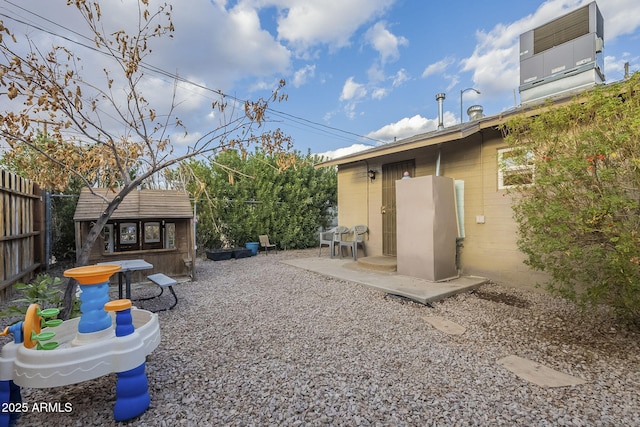 view of yard with a patio area, a fenced backyard, and an outdoor structure