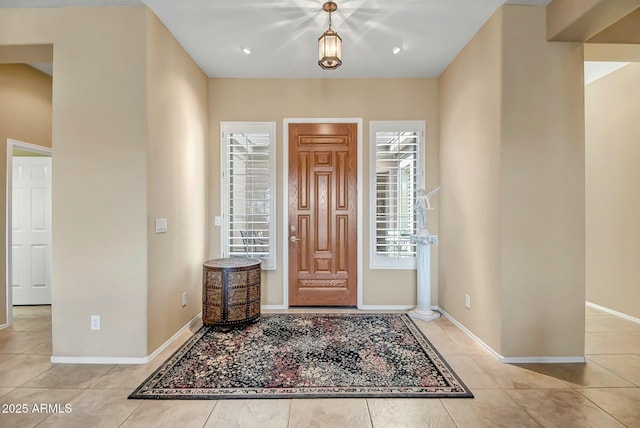 foyer entrance with light tile patterned flooring and baseboards