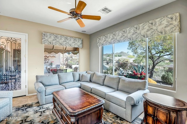 living room featuring tile patterned flooring, visible vents, and a ceiling fan