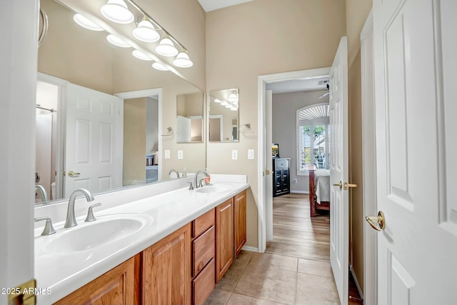 ensuite bathroom featuring tile patterned flooring, a sink, ensuite bath, and double vanity