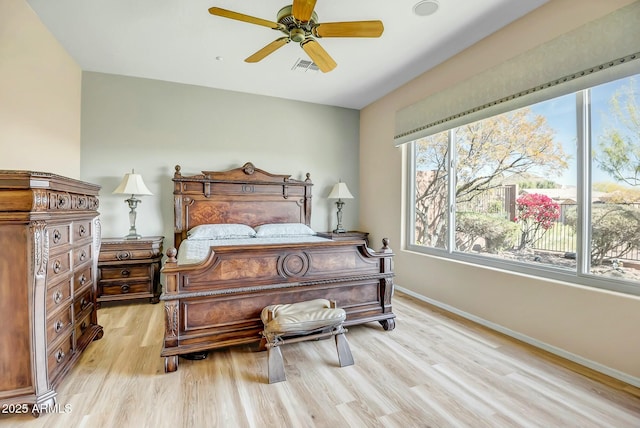 bedroom featuring baseboards, ceiling fan, visible vents, and light wood-style floors