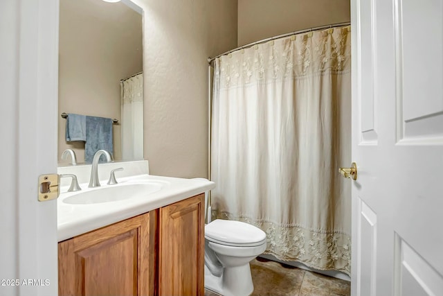 bathroom featuring toilet, curtained shower, a textured wall, and vanity