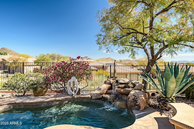 view of swimming pool featuring fence, a mountain view, and a fenced in pool