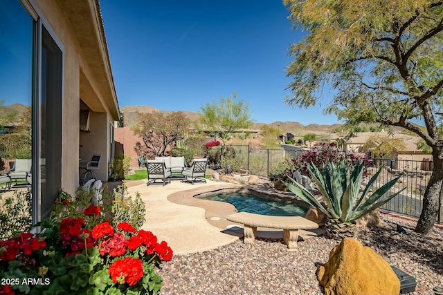 view of pool featuring a fenced in pool, a patio area, a fenced backyard, and a mountain view