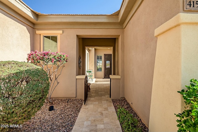 doorway to property featuring stucco siding