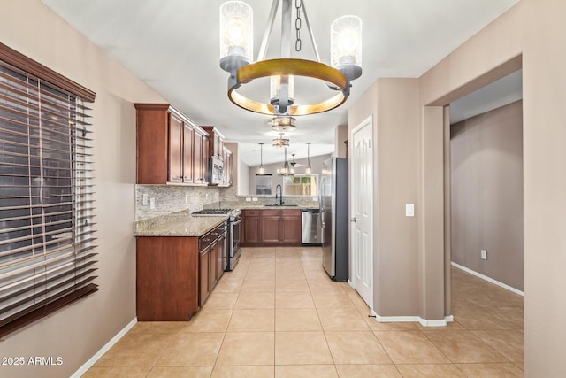 kitchen with light tile patterned floors, stainless steel appliances, a sink, decorative backsplash, and an inviting chandelier