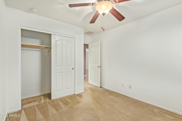 unfurnished bedroom with baseboards, visible vents, a closet, and light colored carpet