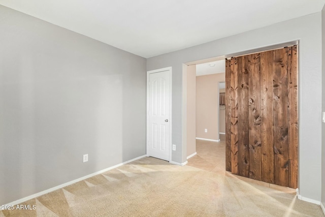 unfurnished bedroom featuring a closet, light colored carpet, and baseboards