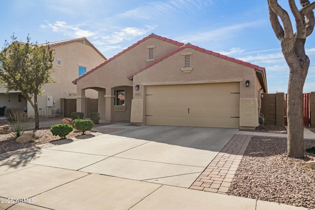 mediterranean / spanish home featuring an attached garage, a tile roof, concrete driveway, and stucco siding