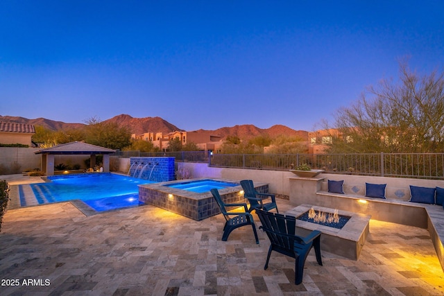 view of pool featuring a fire pit, an in ground hot tub, a mountain view, and a gazebo