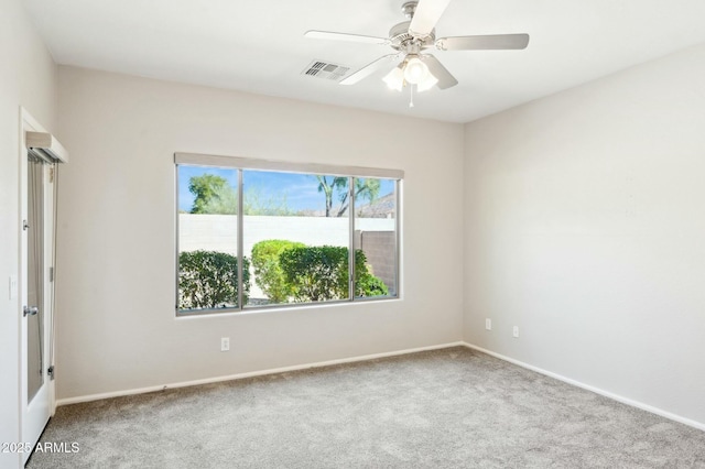 carpeted empty room featuring a ceiling fan and visible vents