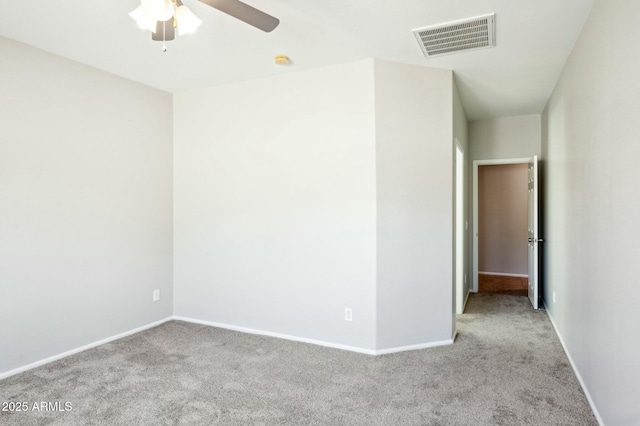 spare room featuring carpet flooring, visible vents, and baseboards