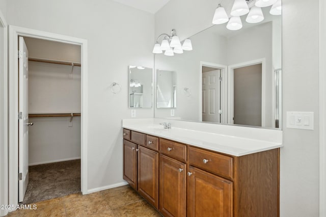 full bath featuring baseboards, tile patterned floors, a spacious closet, vanity, and a chandelier