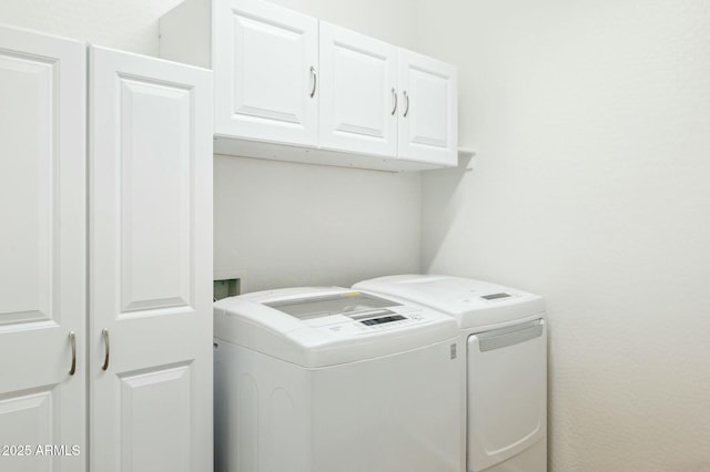 washroom featuring cabinet space and independent washer and dryer