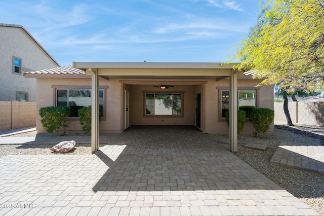 exterior space featuring a patio area, a tiled roof, fence, and stucco siding